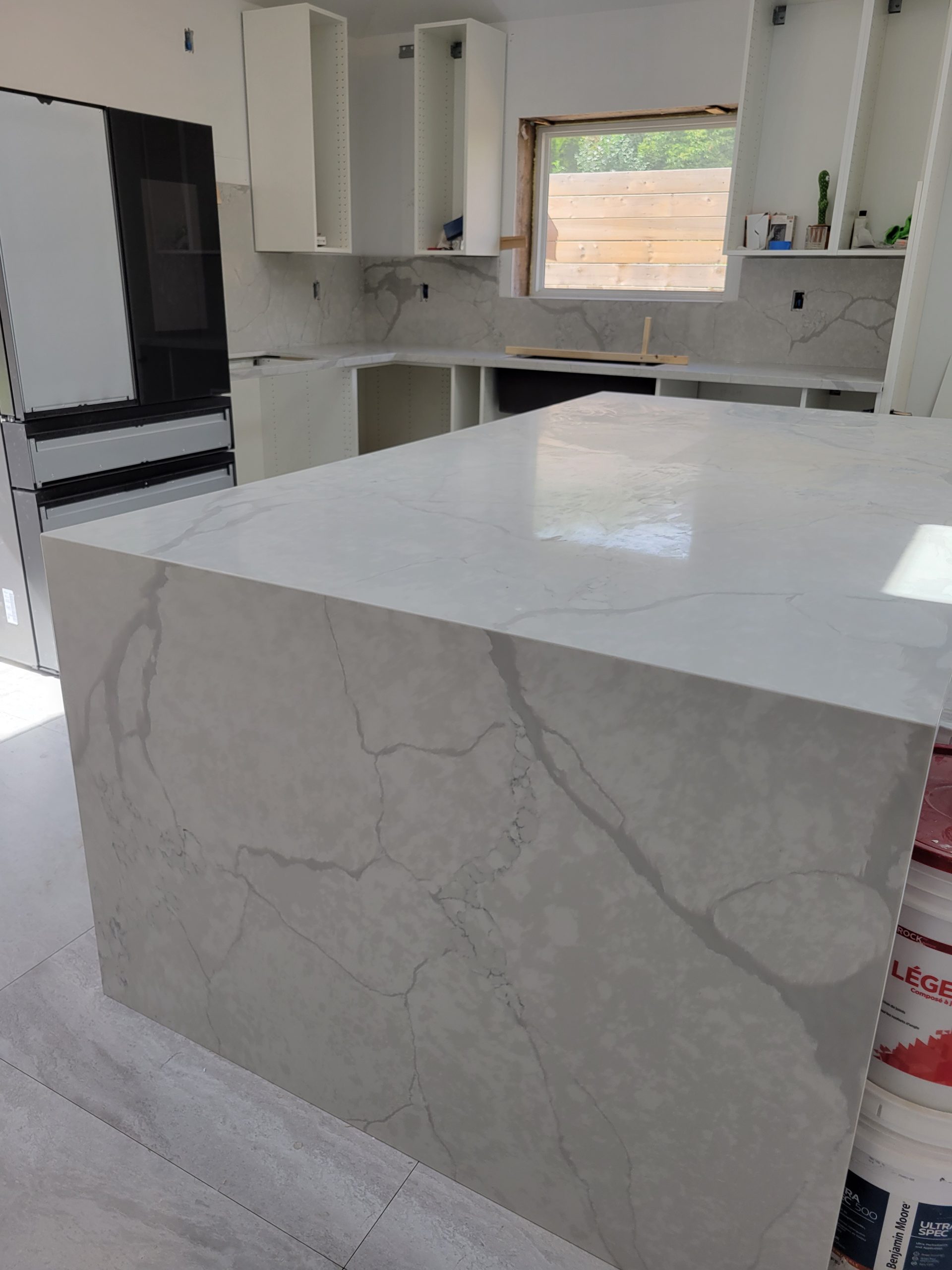 Waterfall countertops 2025 with white quartz island and wood base