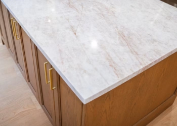 Close-up of a Taj Mahal Quartz kitchen island showing warm gold veining and a smooth polished surface with modern cabinetry.