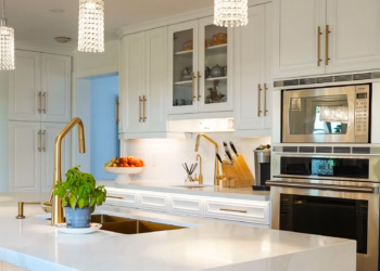 Calacatta Oro quartz countertops in a full kitchen view, showcasing bright gold veining and a clean modern layout.