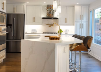 Calacatta Oro quartz countertop installed in a modern kitchen, showing the soft gold veining and polished surface.