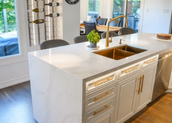 Close-up view of a Calacatta Oro quartz kitchen island showing detailed gold veining and a polished finish.