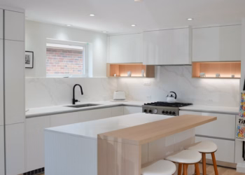 Modern kitchen featuring Calacatta Oro Quartz countertops with a half-quartz, half–butcher block island design, full-height backsplash, and integrated white cabinetry installed by Stone Valley Countertops.