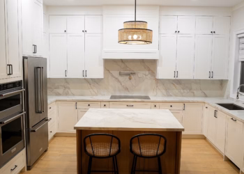 Modern white kitchen featuring Lupas quartz countertops, full-height quartz backsplash, and a matching island with warm wood accents.