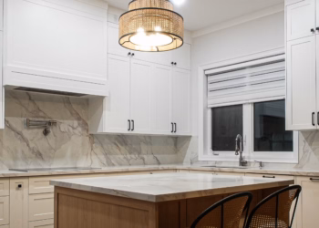 Modern kitchen with a Lupas quartz island and full-height quartz backsplash featuring elegant natural veining.