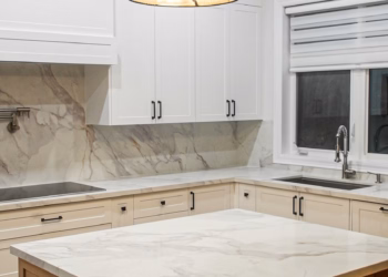 Close-up view of a Lupas quartz kitchen island with matching quartz countertops and full-height backsplash in a modern white kitchen.