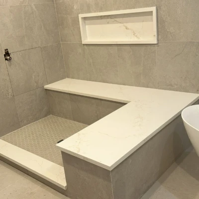 Quartz shower bench and wall ledge installed in luxury bathroom renovation in Bewdley Ontario