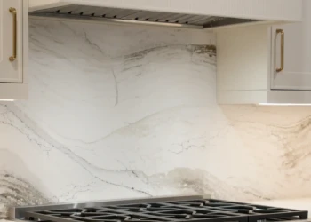 Cambria Windsor Brass Satin Ridge quartz full height backsplash behind range with under cabinet lighting in Mississauga kitchen